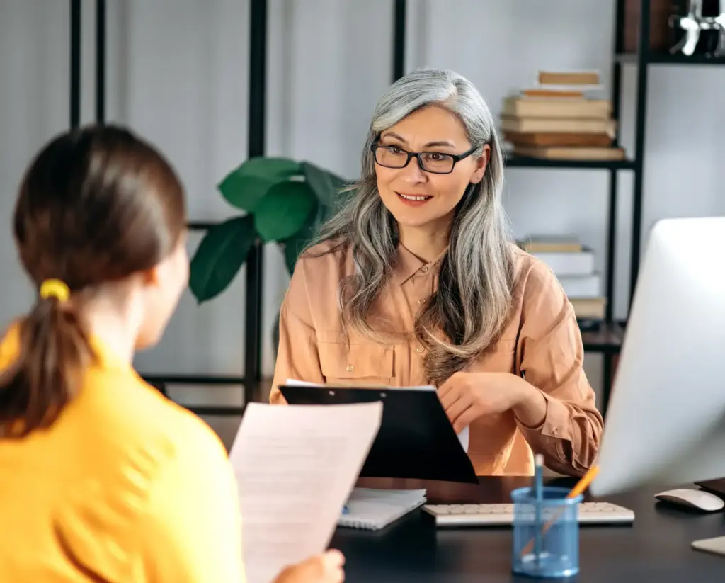 Manager reviewing documents with an employee during an office meeting