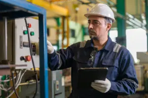 Electrical supervisor inspecting equipment with arc flash safety gear