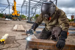 Welder working on steel structure construction site