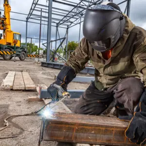 Welder working on steel structure construction site