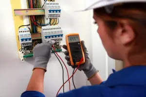 Electrician testing voltage on electrical panel