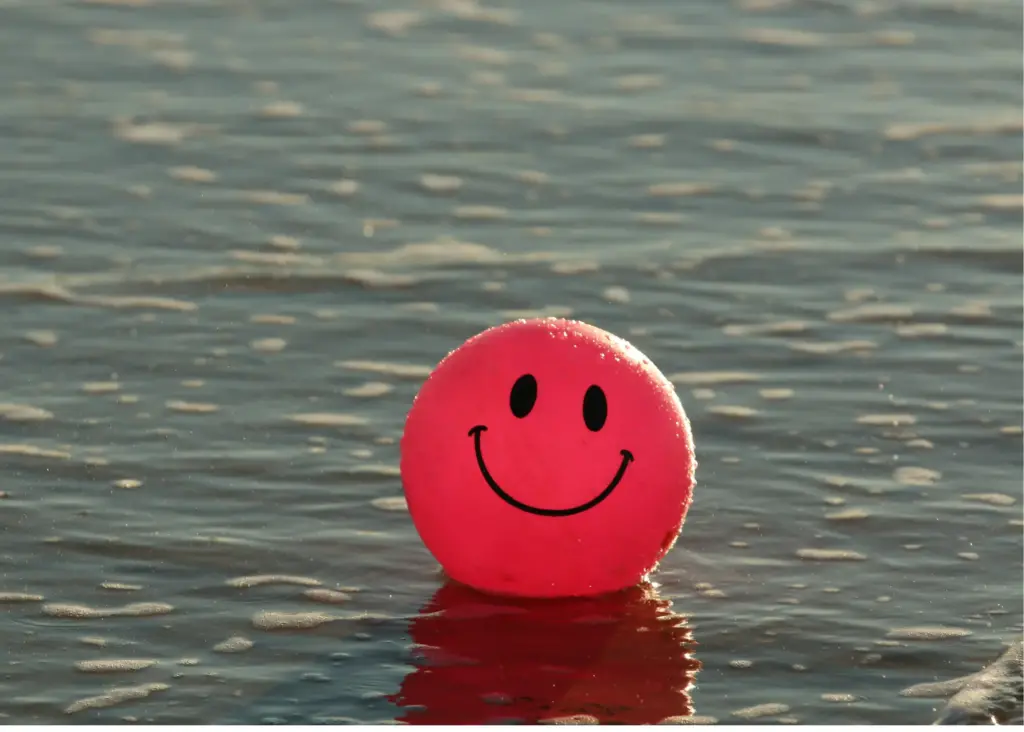 Pink smiley face ball floating on water