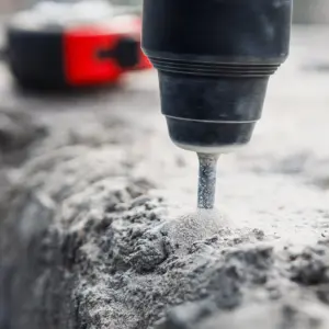 Power drill drilling into concrete surface