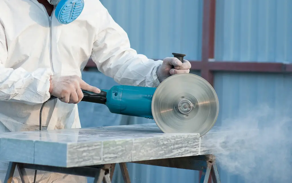 Worker cutting stone slab with circular saw